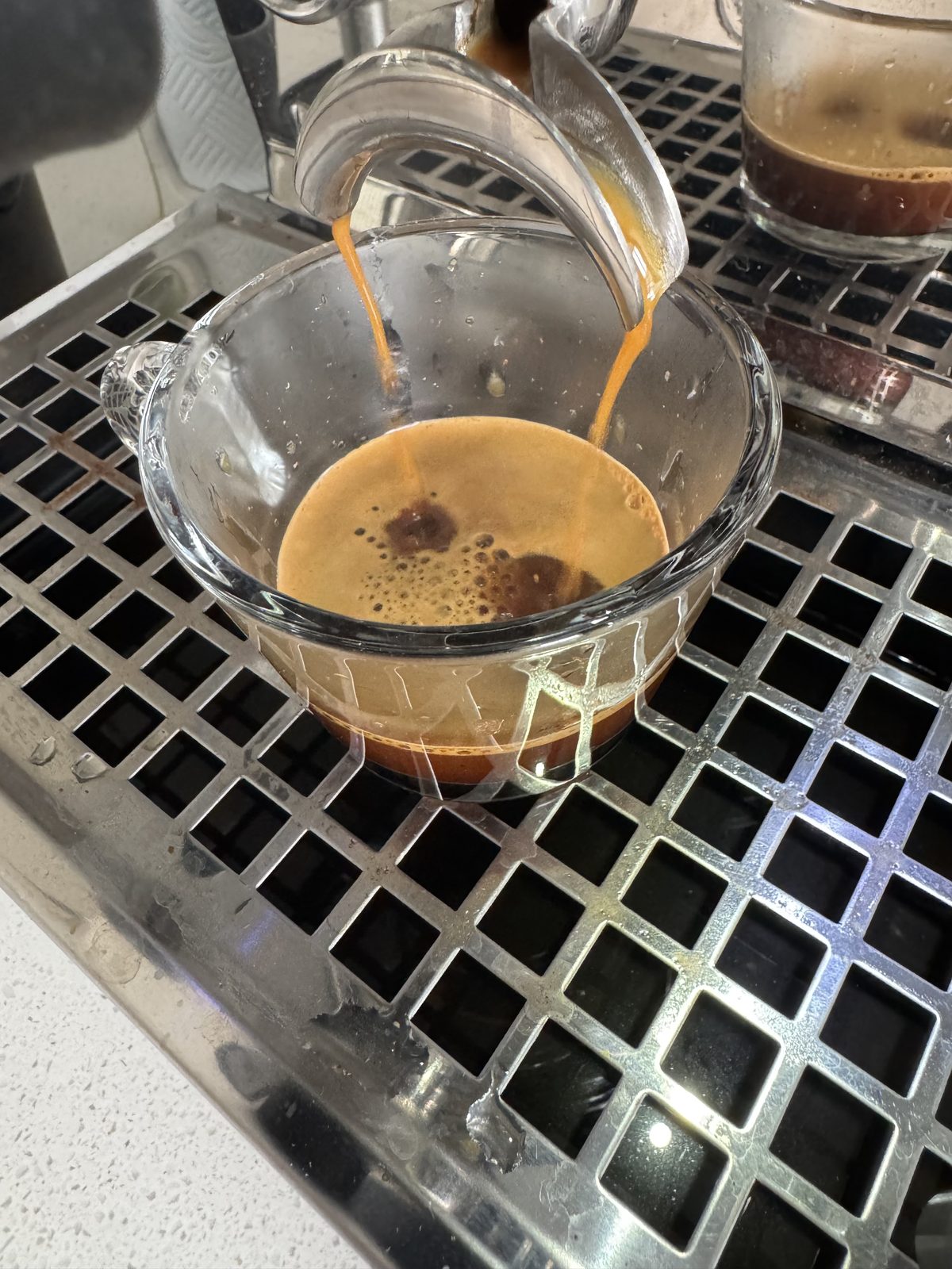 Espresso being poured from a portafilter into a cup